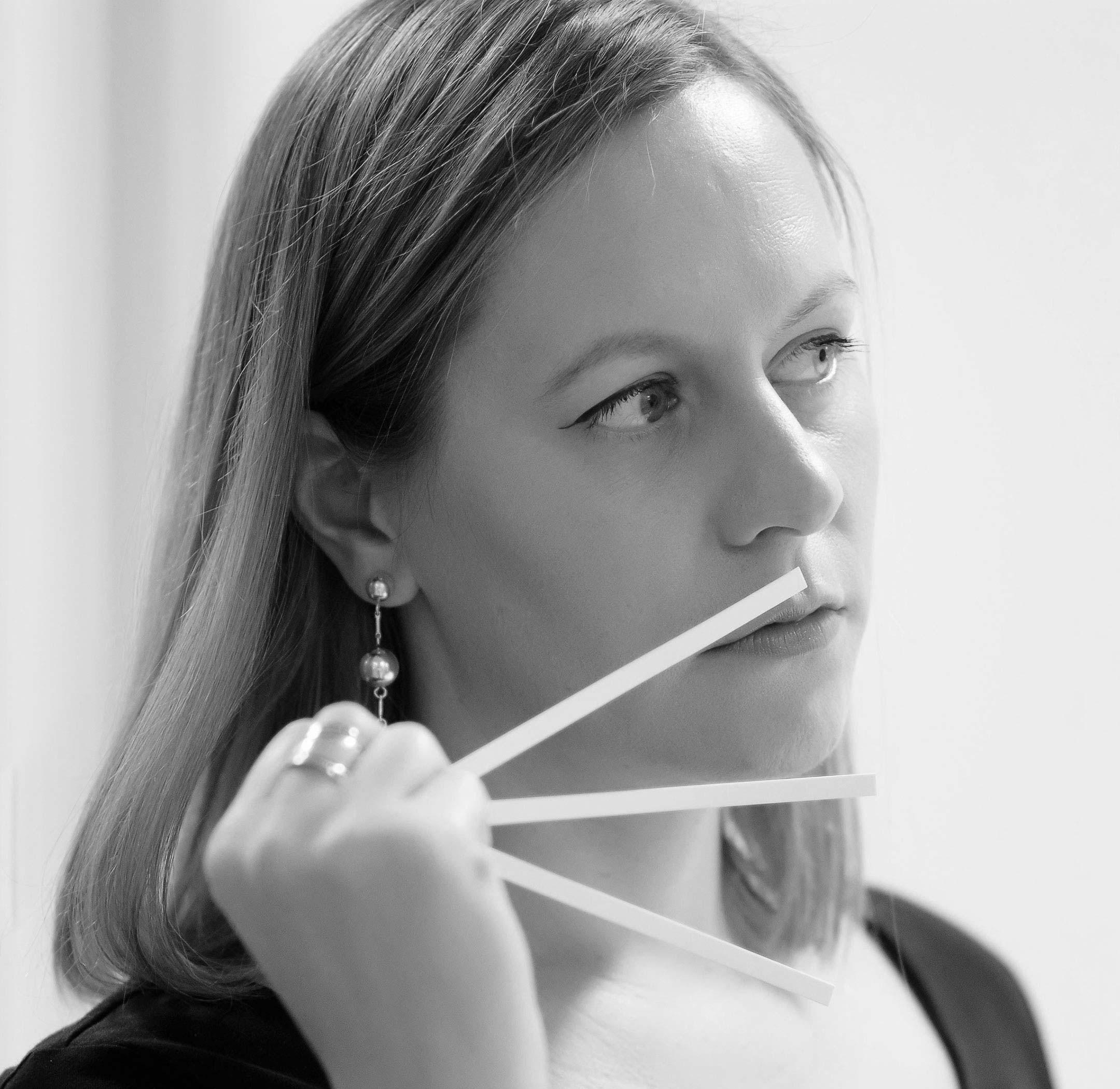 An image of Julie Pluchet holding frangrance sticks to her nose